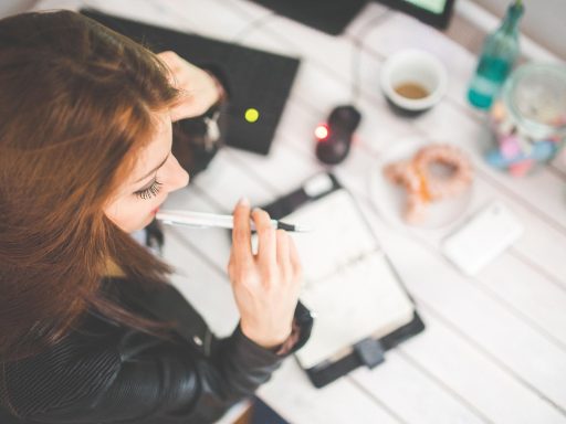 Persoon die nadenkend achter een bureau zit en oriënteert op ondernemerschap