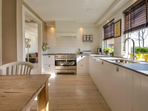 Een warme Scandinavische woonkamer met licht eikenhout, linnen kussens en zachte verlichting