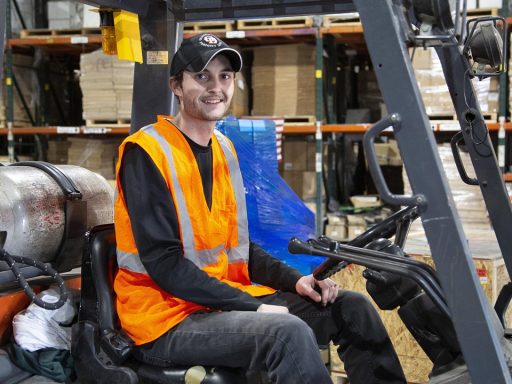 Magazijnmedewerker rijdt met een heftruck door een groot distributiecentrum