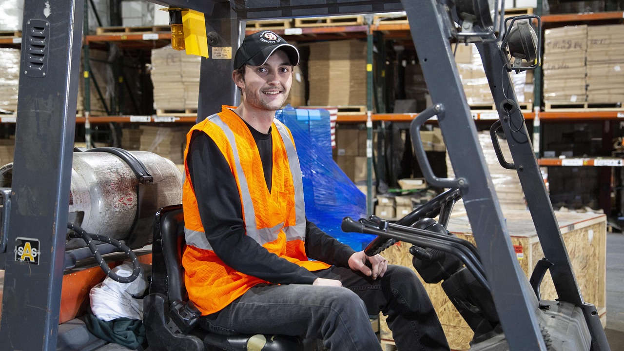Magazijnmedewerker rijdt met een heftruck door een groot distributiecentrum