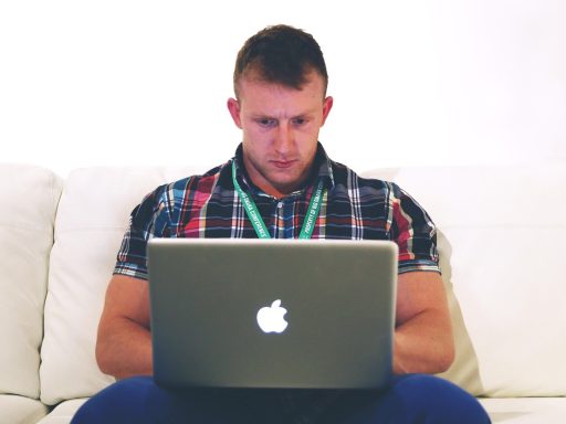 IT-freelancer die werkt aan een laptop in een thuiskantoor en zijn kosten berekent