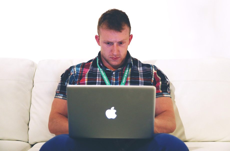 IT-freelancer die werkt aan een laptop in een thuiskantoor en zijn kosten berekent