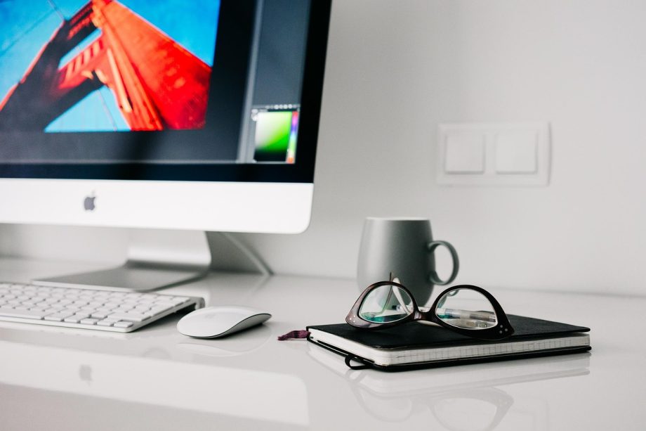 Persoon aan een opgeruimd bureau thuis, geconcentreerd aan het werk op een laptop