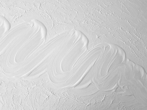 Een witte paneelradiator wordt stap voor stap geschilderd met een smalle kwast en hittebestendige radiatorverf